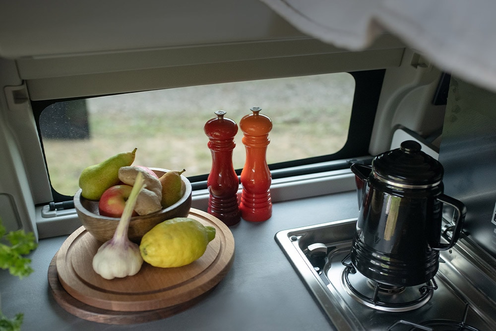 - Ford Transit Custom Nugget con cucina integrata: piano cottura con bollitore e frutta sul bancone