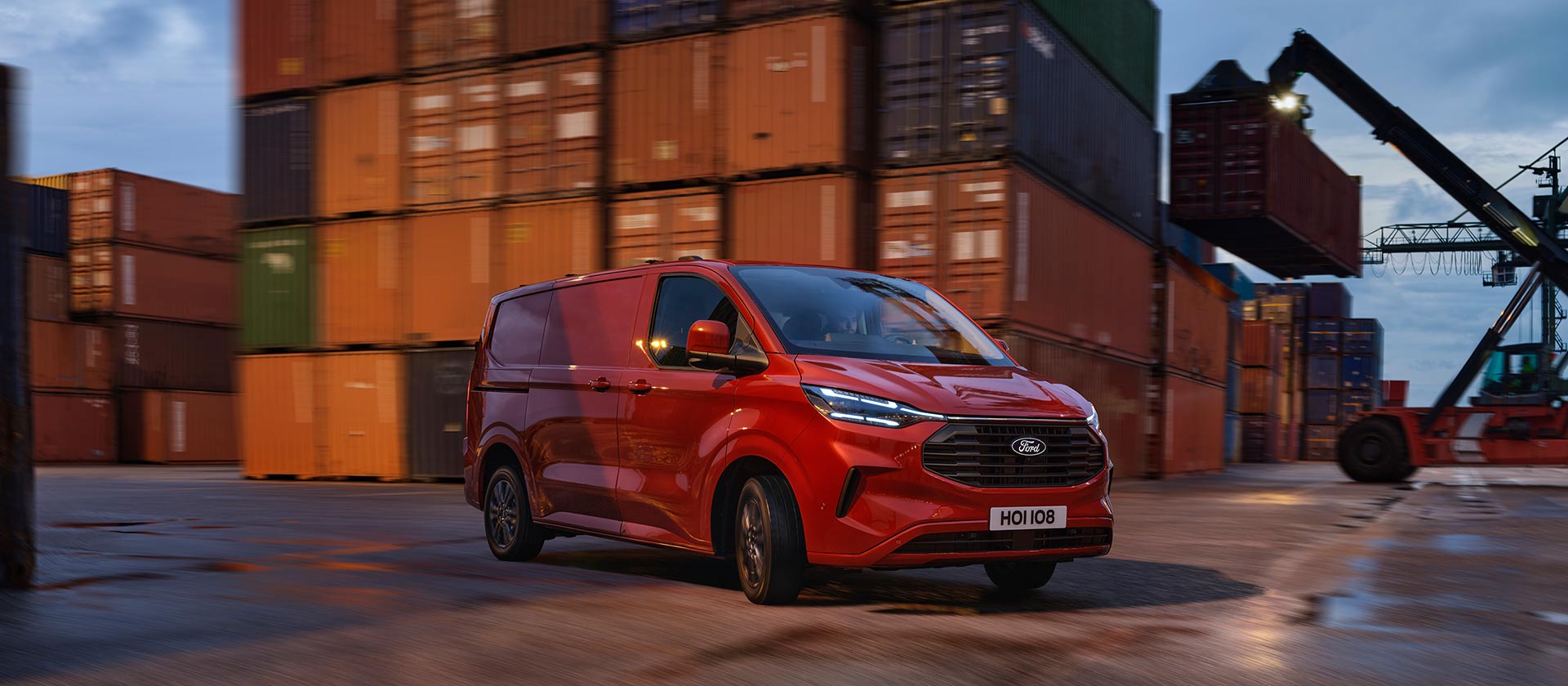 Un furgone Ford Transit Custom rosso attraversa un molo.