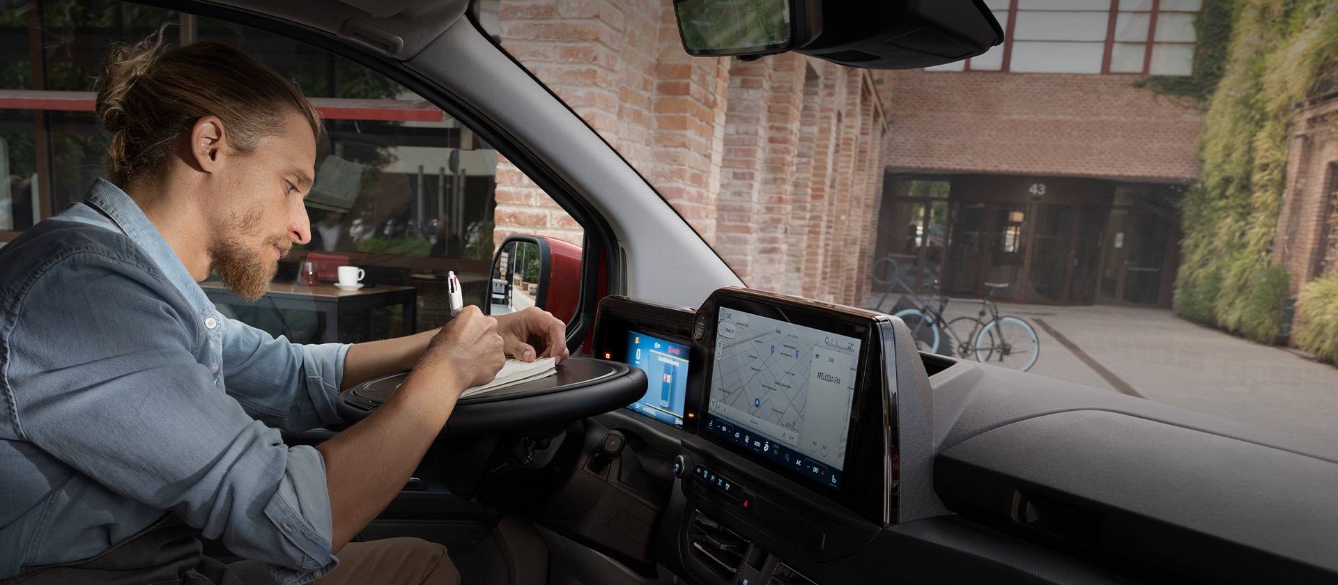 Una persona digita su un notebook all'interno di un Ford Transit Custom.