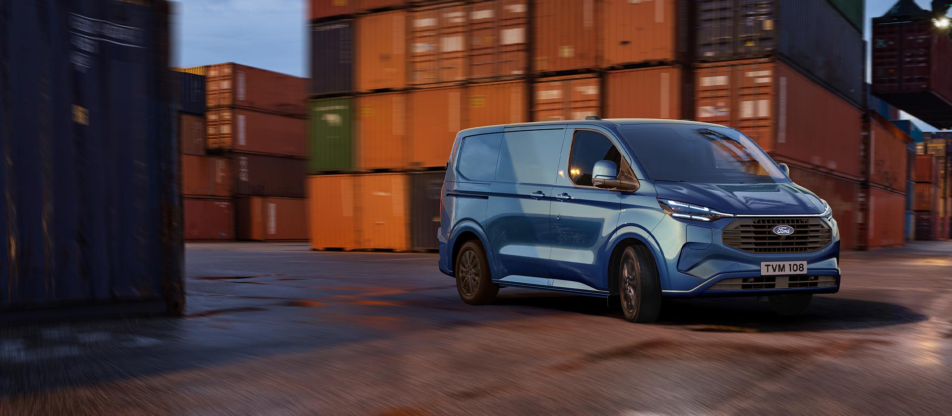 Un furgone Ford Transit Custom Plug-in Hybrid blu attraversa un molo.