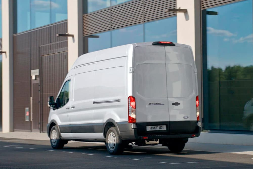 Vista posteriore di un furgone Ford Transit versione bianca parcheggiato su una strada.