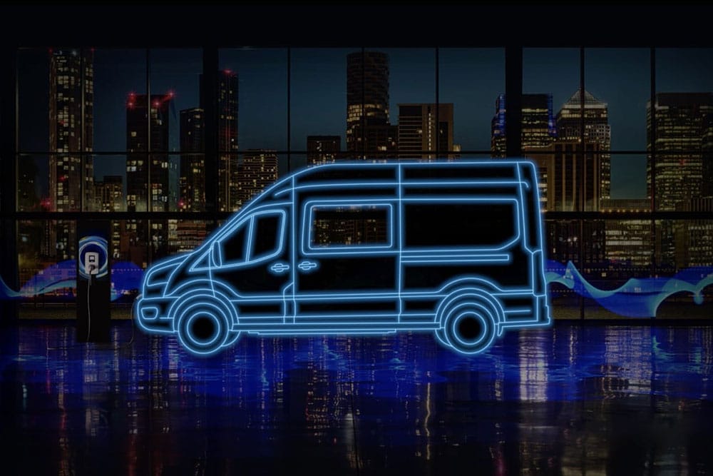 Il profilo neon blue di un furgone a doppia cabina Ford E-Transit e una stazione di ricarica con una città sullo sfondo.
