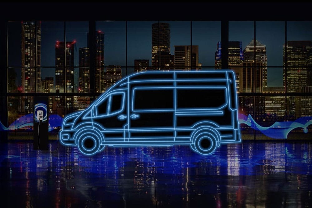 Il profilo neon blue di un furgone elettrico E-Transit e una stazione di ricarica con una città sullo sfondo.