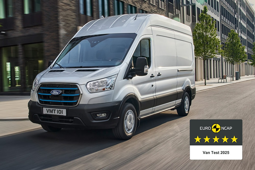Un furgone elettrico Ford E-Transit che percorre una strada con un badge "Gold 2022 Commercial Van Safety".