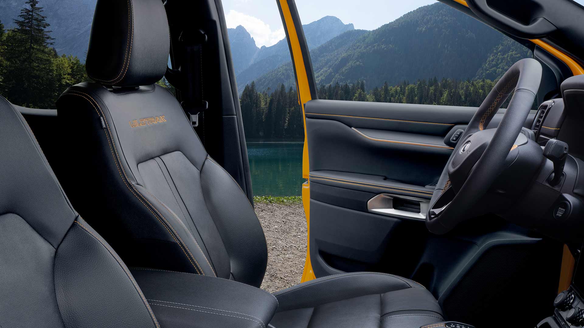 Vista sugli interni di un Ford Ranger Wildtrak con sedili in pelle nera e ricamo "Wildtrak" giallo.