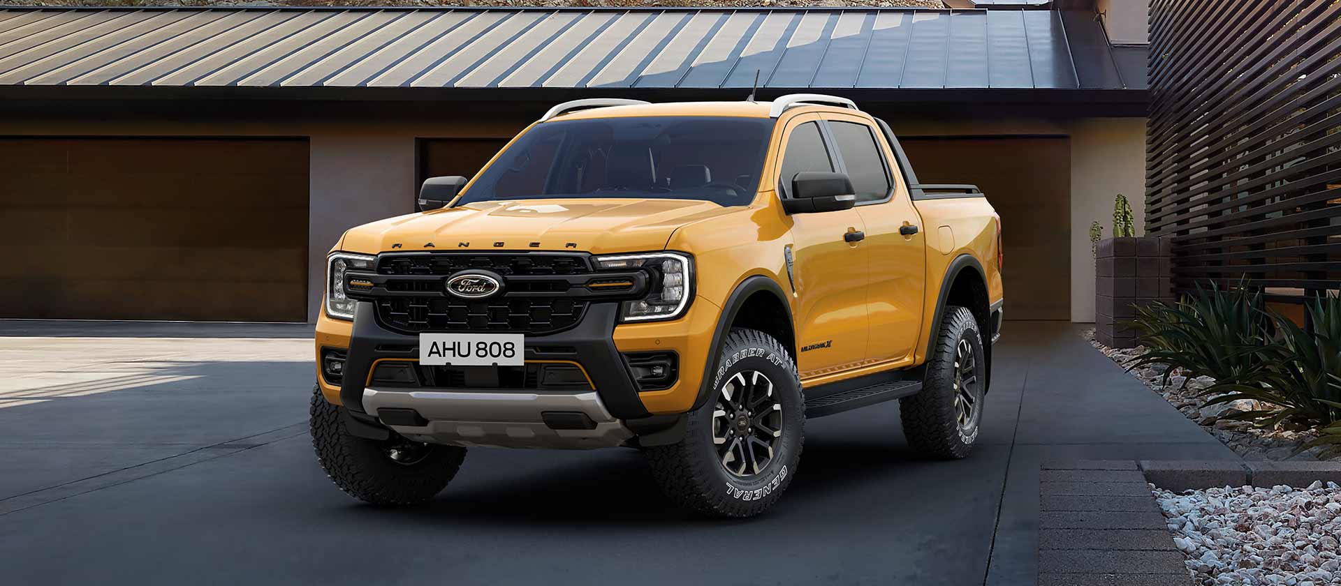 Ford Ranger Doppia Cabina giallo parcheggiato davanti a una casa.