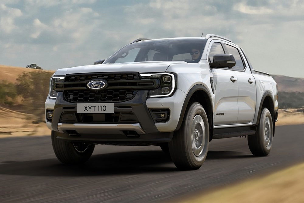 Un Ford Ranger PHEV Stormtrak percorre una strada rurale.