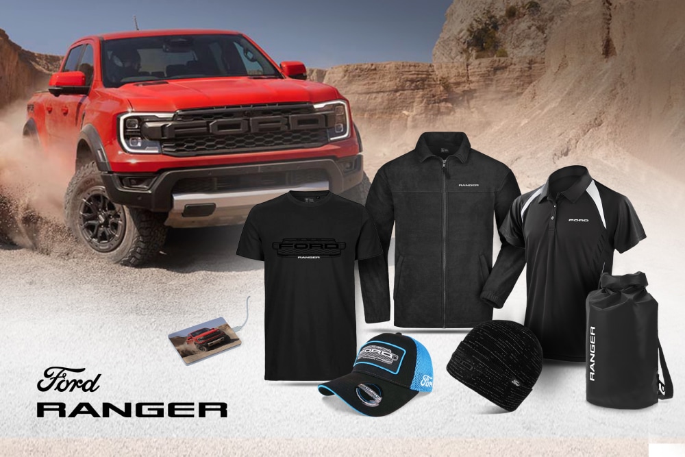 Ford Ranger Collection with black t-shirt, jacket, polo, cap, beanie, and wetpack, and a red Ranger in the background.
