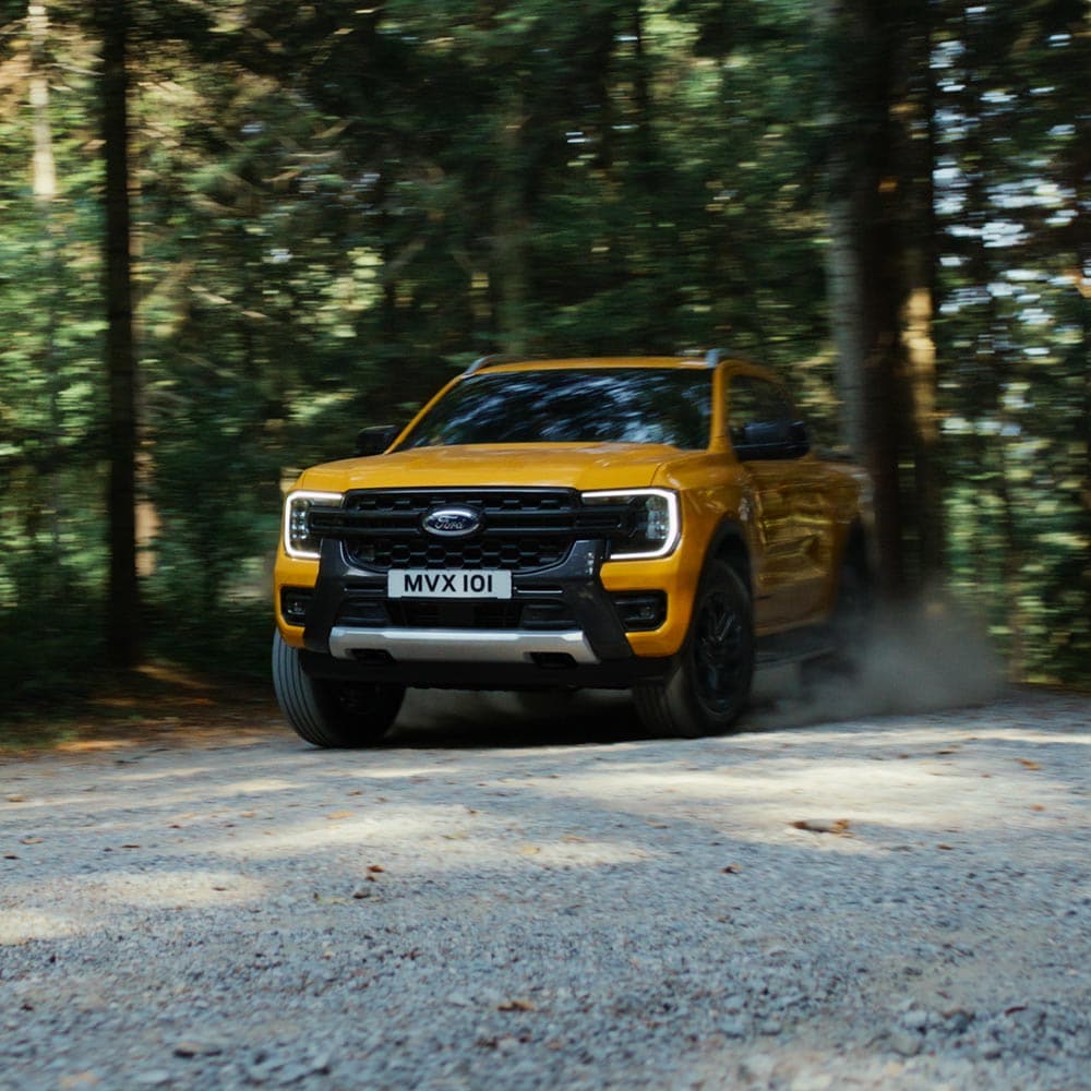 Video di un Ford Ranger Wildtrak Doppia Cabina giallo che percorre strade di montagna e sentieri di ghiaia.