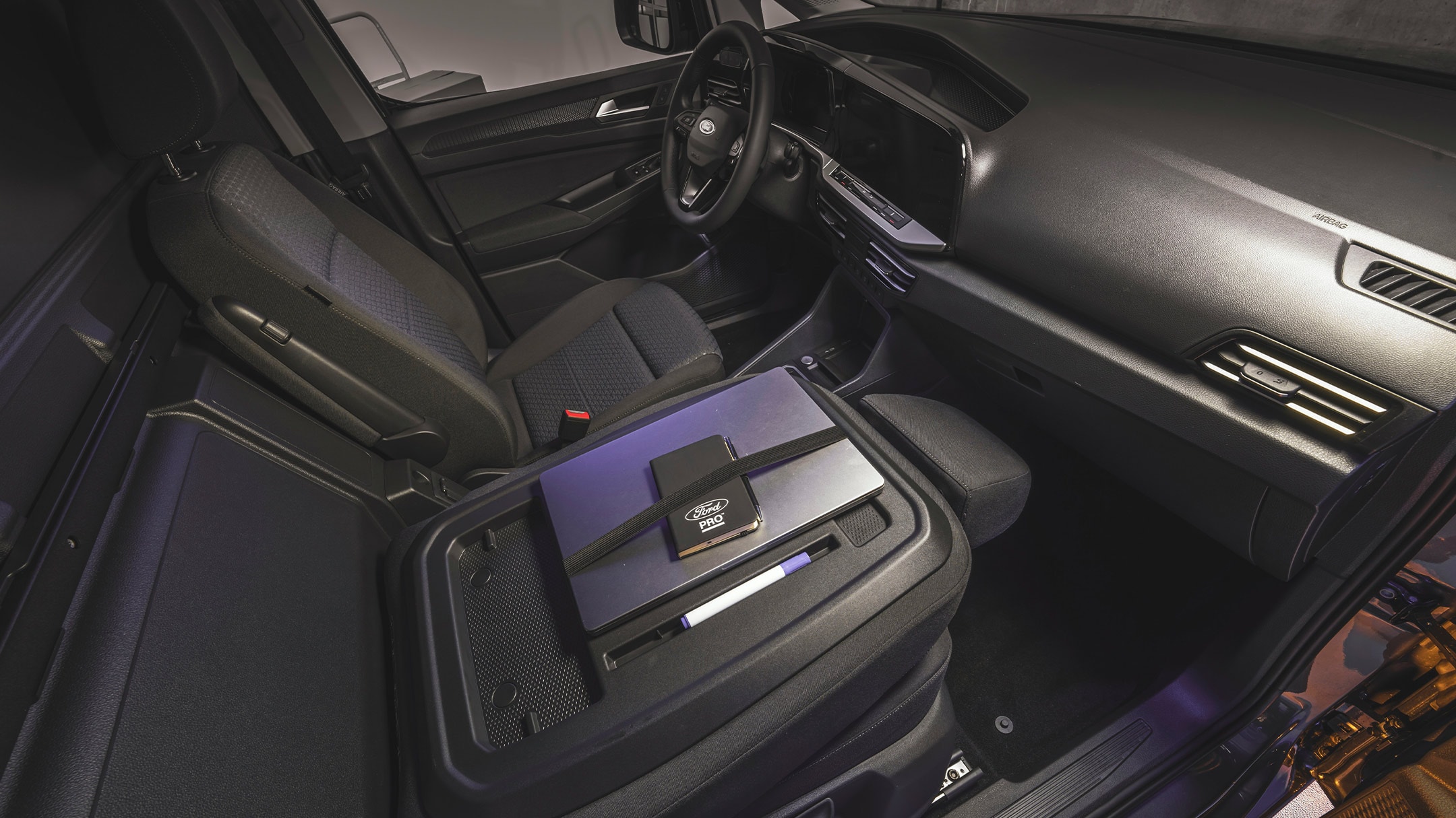 Un laptop e un notebook Ford Pro sono appoggiati sul tavolo del piano di lavoro del nuovo Ford Transit Connect.