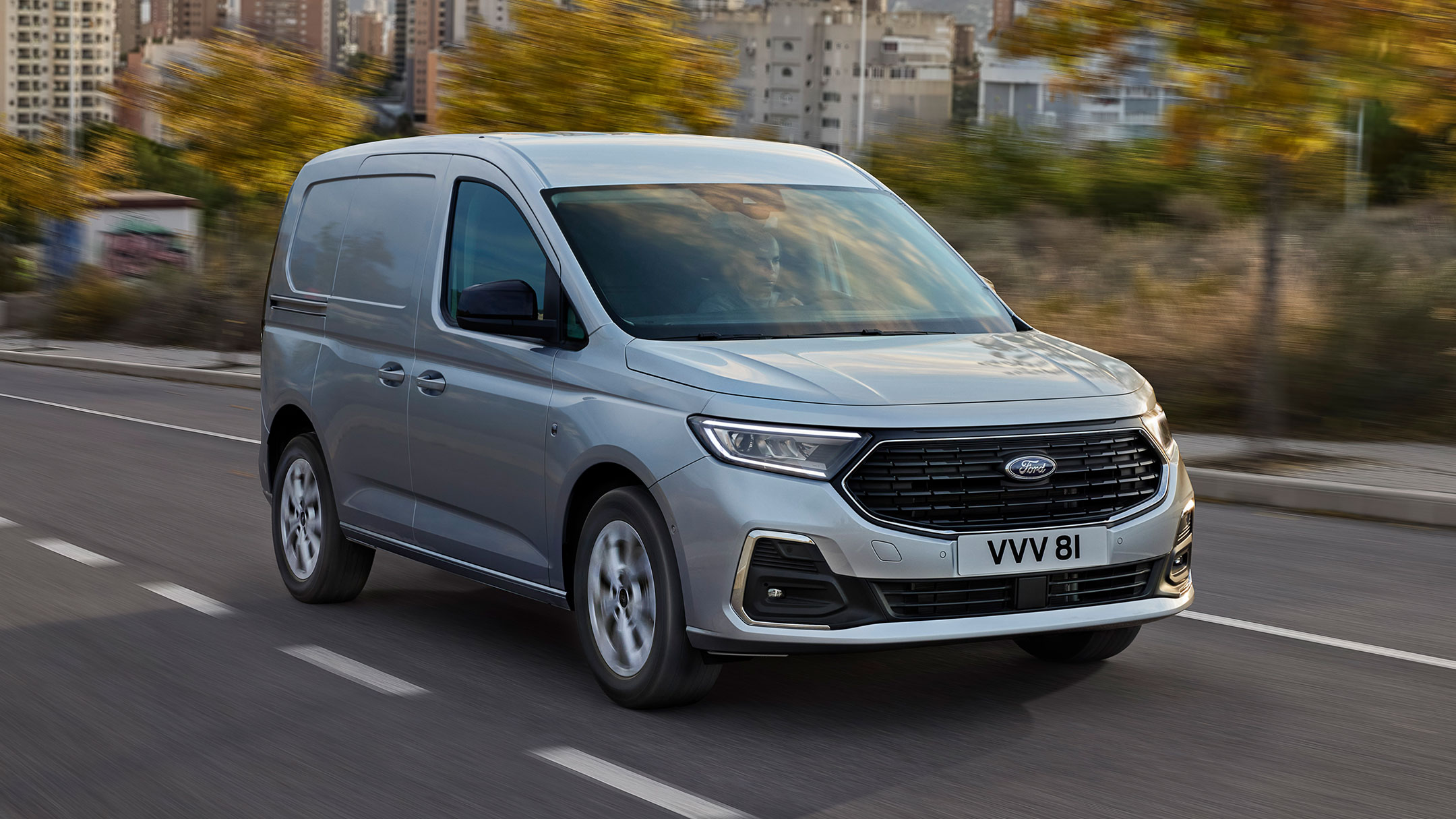 Nuovo Ford Transit Connect Limited in Stardust Silver in marcia su una strada, con i bordi esterni cromati e i fari automatici in evidenza.