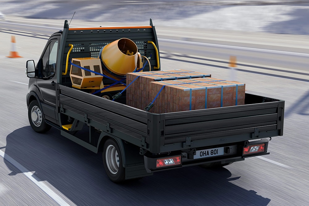 Ford Transit Chassis in movimento con carico nel vano posteriore.