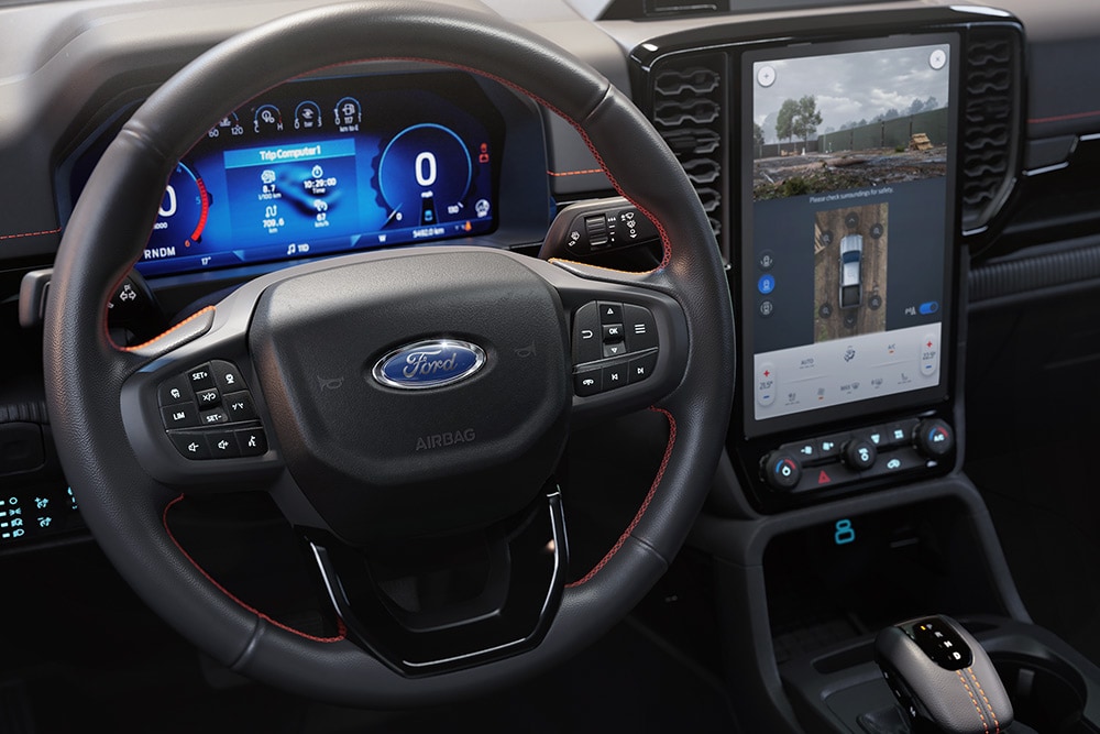 Vista degli interni del Ford Ranger Wildtrak che mostra il volante, la console centrale del SYNC™ 4 con touchscreen da 12 pollici.