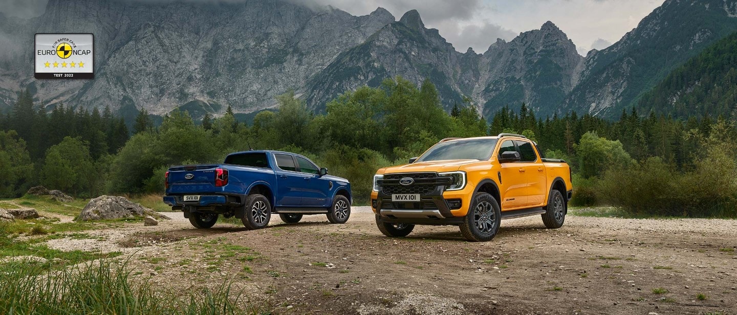 Orange Ford Ranger 3/4 front view on gravel in front of Blue Ford Ranger 3/4 rear view