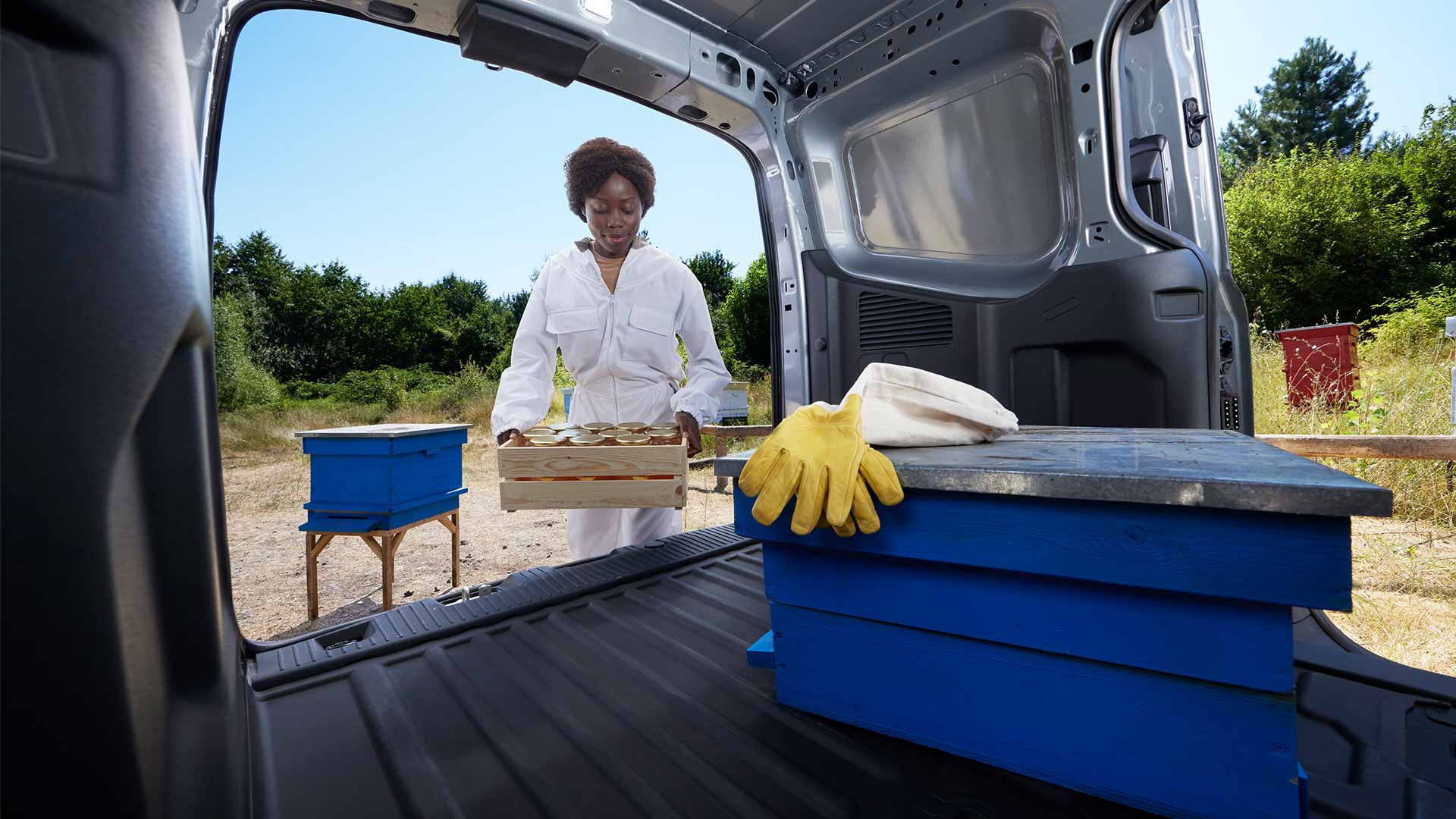 Apicoltore che carica il miele in un Ford Transit Courier