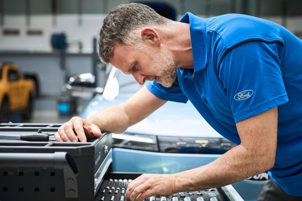 Primo piano di un tecnico autorizzato Ford al lavoro in un'officina.