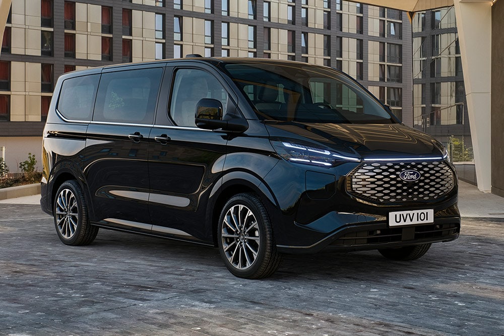 Ford Pro Transit nero parcheggiato di fronte a un edificio moderno.