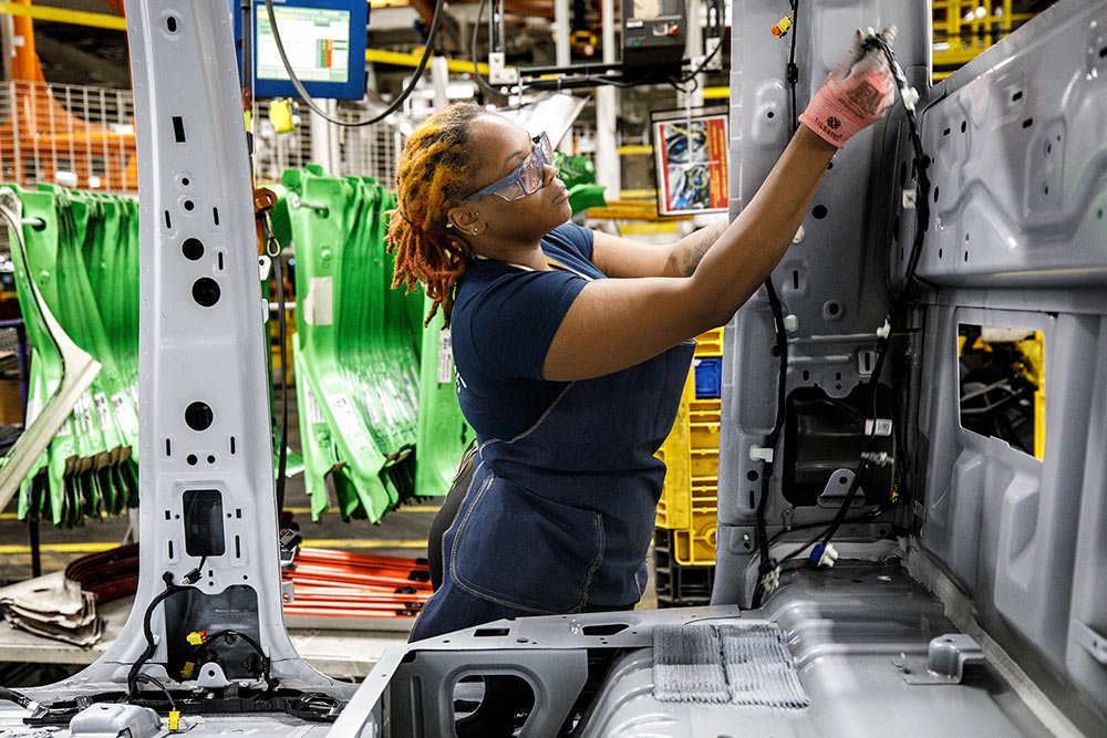 Meccanico Ford che lavora su un furgone in un'officina.