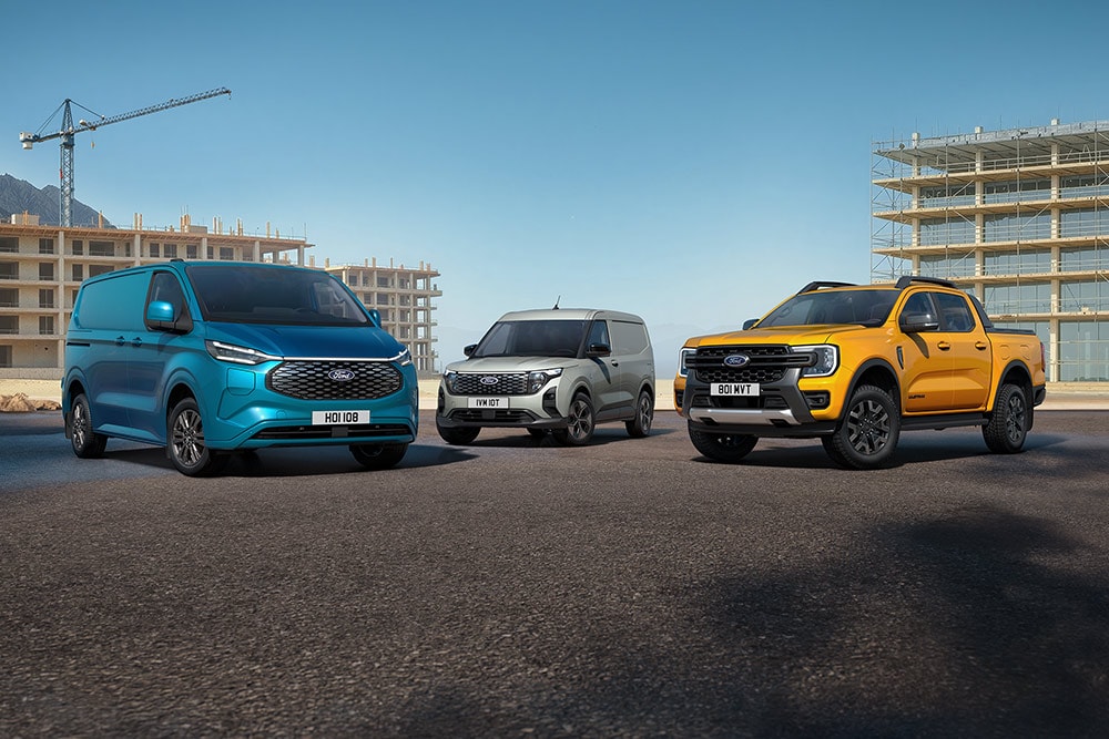 Una collezione di veicoli Ford parcheggiati di fronte a un cantiere.