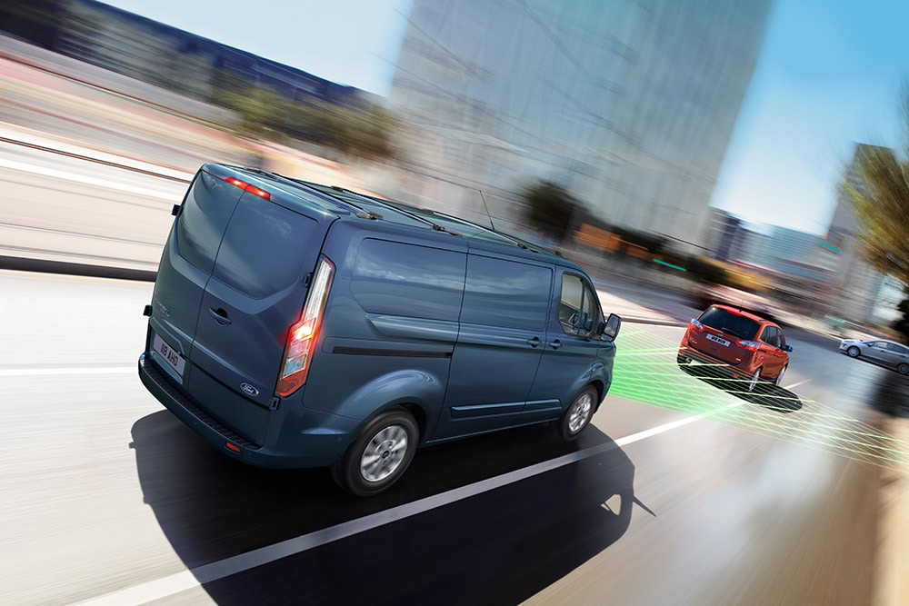 Vista posteriore di un furgone Ford blu, con linee verdi che indicano le funzioni di assistenza alla guida.