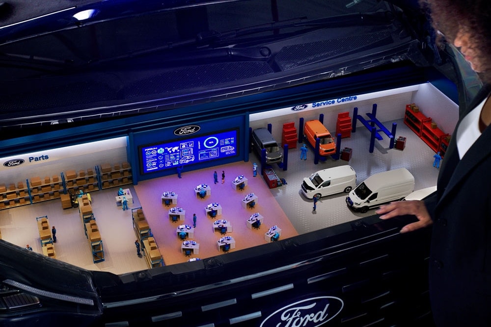 Modello in miniatura di un centro assistenza Ford all'interno del bagagliaio di un'auto.