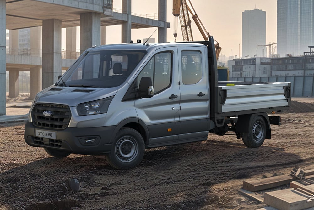 Un telaio scheletro Ford E-Transit bianco parcheggiato in un cantiere.
