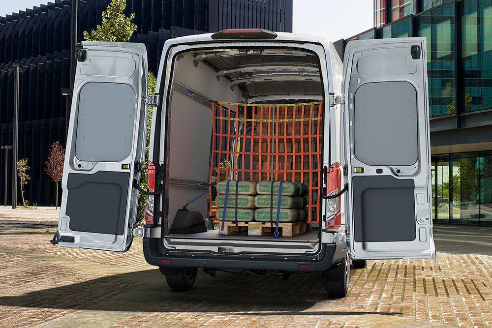 Una vista posteriore dell'interno di un furgone Ford bianco parcheggiato vicino a edifici per uffici.