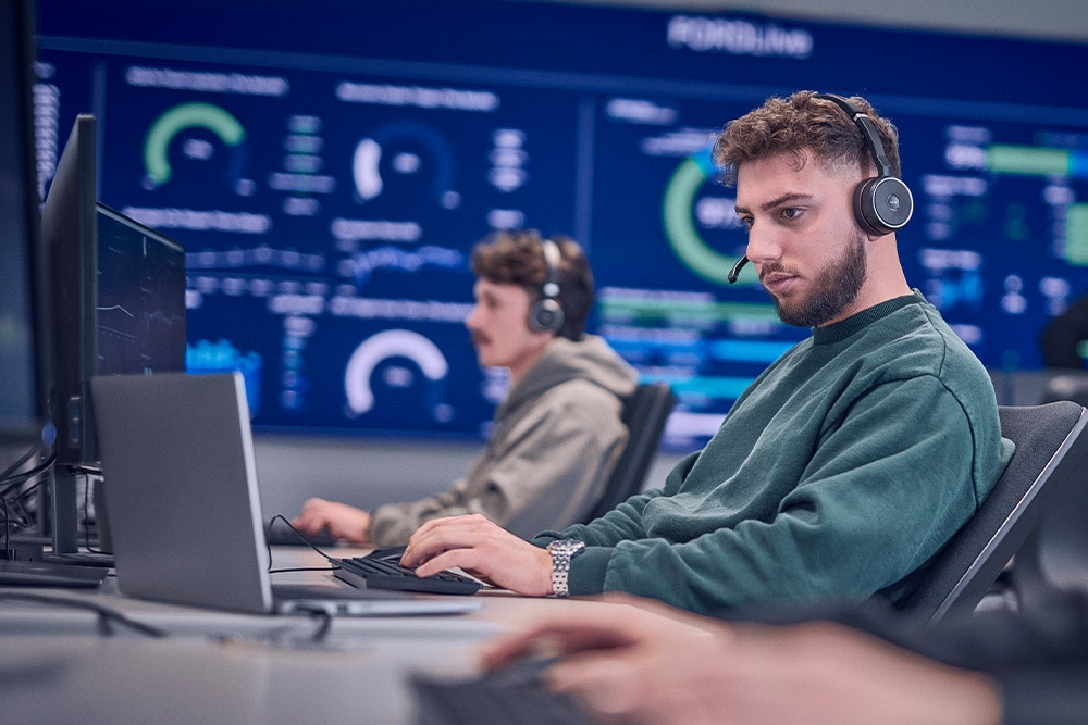 Un lavoratore Ford con cuffie che lavora al suo laptop.